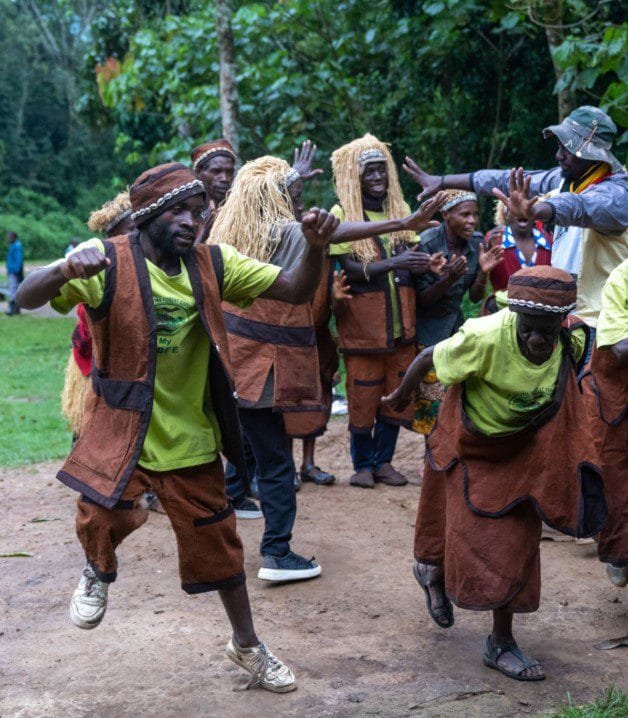 Batwa elders performing traditional dance in a forest clearing, showcasing rich cultural heritage and ancestral forest traditions.