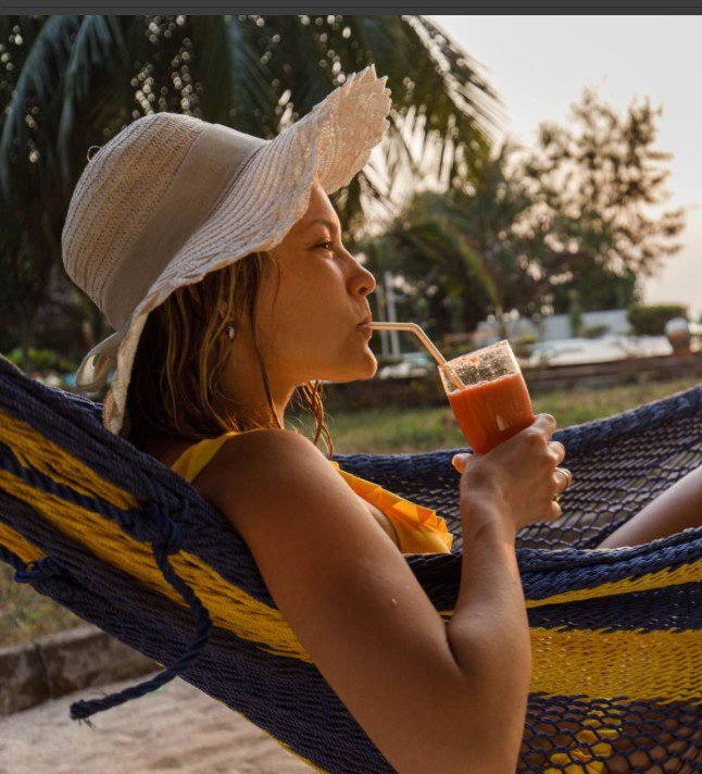 A colorful display of traditional Tanzanian drinks including chai, banana beer, and tropical fruit juices served in local cups.