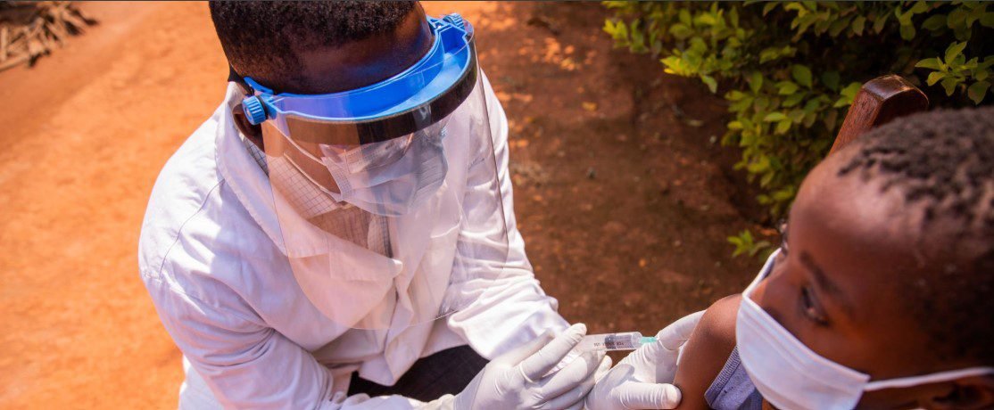 A healthcare professional administering an injection to prevent malaria in a patient.